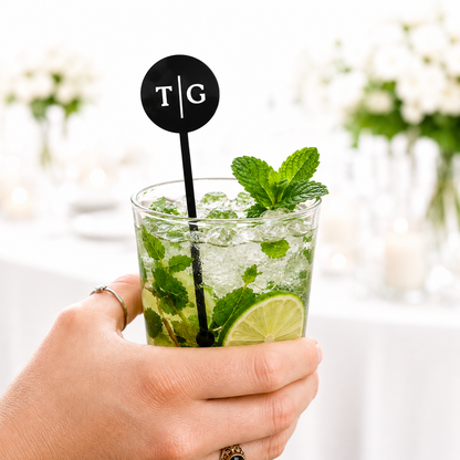 Black circle initials T|G stir stick in a mojito