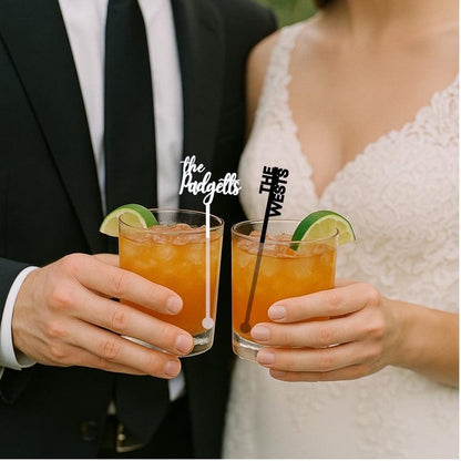 Bride and groom holding cocktails with personalized name stir sticks