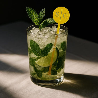 Gold circle initials stir stick in a mojito in sunlight