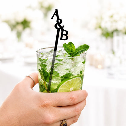 Black A&B stacked initials stir stick in a mojito, close up